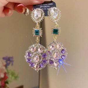 Macro shot of ethnic style earrings with colorful zircon crystals and silver 925 hooks