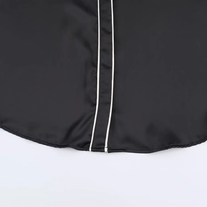 Women's black satin shirt featuring elegant white contrast piping and silky texture details