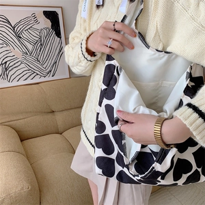 Detail of canvas tote bag showing interior lining, open inner pocket, and heart print