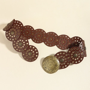 Detail of vintage brown leather disc belt with ornate brass buckle and metal eyelets