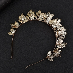 Detailed view of a golden leaf alloy headband on a textured black background