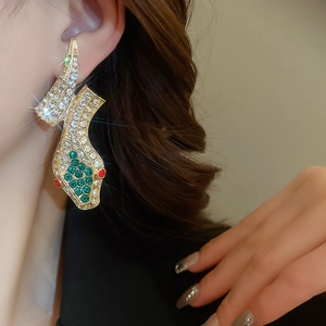 Close-up of vintage gold snake earrings with sparkling white, green and red crystals