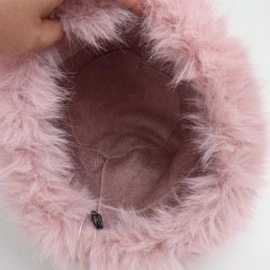 Detailed interior of the pink faux fur hat showing the soft lining and care label