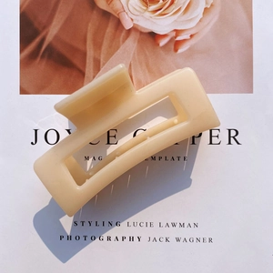 Detail view of a beige matte acrylic rectangular hair claw clip with cutout design