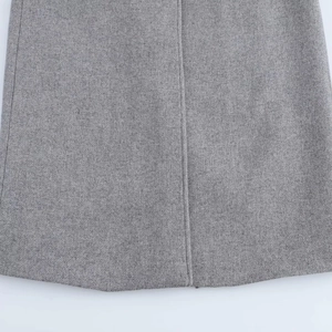 Detailed close-up of premium gray wool fabric texture and neat vertical hem stitching