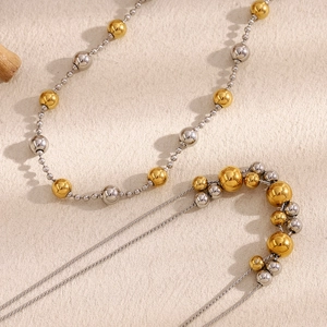Close-up of double-layered 18K gold and silver beaded necklace with smooth metal texture