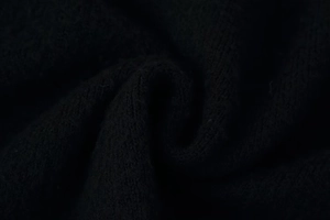 Macro view of black knit fabric texture showing vertical ribbed details and soft drape