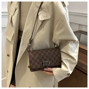 Close-up of vintage brown geometric shoulder bag with gold metal lock and chain strap