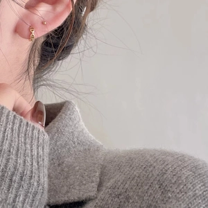 Minimalist gold chain hoop earrings and small stud set worn with casual knitwear