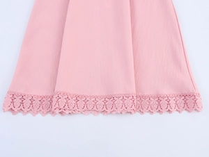 Detail of pink dress featuring delicate lace hem trim and textured fabric finish