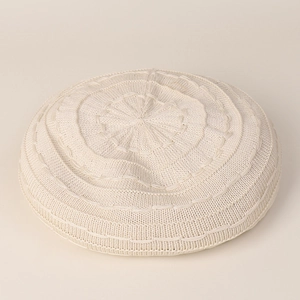 Detail of knit beret featuring concentric circular weaving and radial top pattern