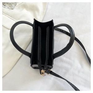 Vue de dessus montrant l'intérieur spacieux avec poche zippée de ce sac à main noir en similicuir