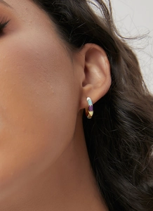 Detailed view of colorful enamel bamboo-style hoop earrings worn by a model