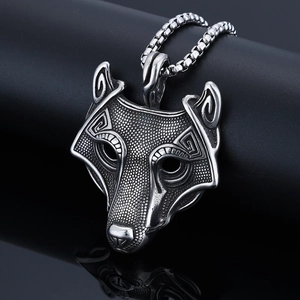 Detailed close-up of viking wolf head pendant with etched texture and silver box chain