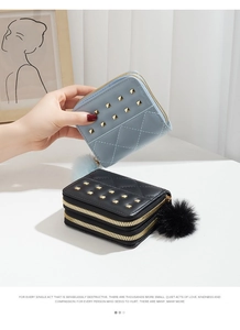 Détail du mini porte-monnaie à double fermeture éclair avec rivets dorés et pompon