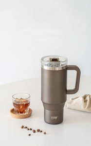 Close-up of matte coffee vacuum tumbler with handle and spill-proof lid detail