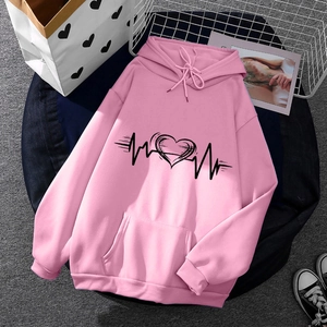 Pink fleece hoodie for men and women featuring black heart print on a lifestyle background