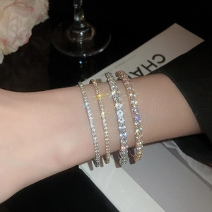 Close-up of stacked gold and silver rhinestone bangles on a woman's wrist