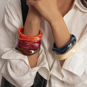 Vue détaillée de larges bracelets en résine colorée avec texture ondulée et brillante