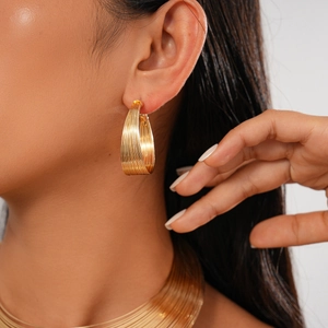 Detailed close-up of gold striped textured hoop earrings and matching choker necklace