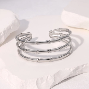 Détail du bracelet argenté à articulations de bambou poli sur un support en pierre
