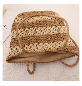 Close-up of woven straw shoulder bag with floral patterns and a secure zipper closure