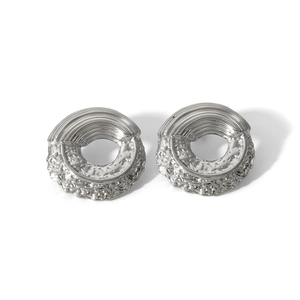 Detail of silver hollow hoop earrings with textured grooved and hammered surface design