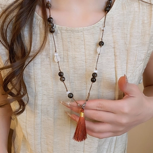 Close-up of vintage beaded necklace with brown silk tassel and translucent stones