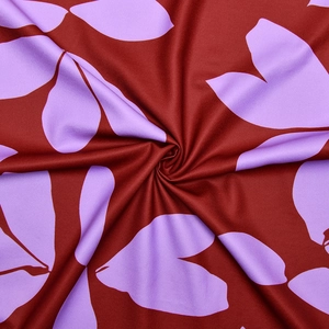 Gros plan d'un tissu floral doux avec des motifs rouge foncé et violet clair pour robe