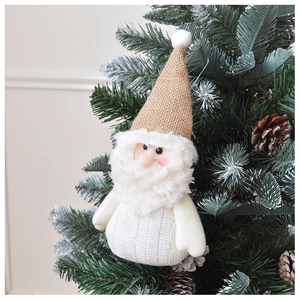 Close-up of knit Santa Claus ornament with burlap hat hanging on a Christmas tree