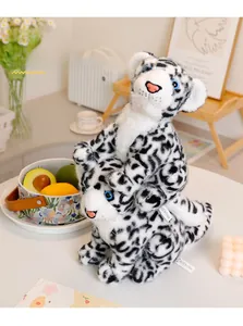 Detailed close-up of soft snow leopard plush toy set with realistic blue eyes and spots