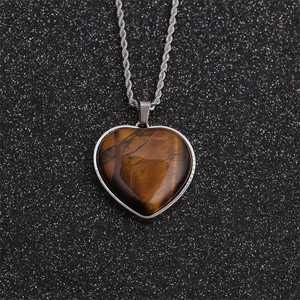 Macro detail of heart-shaped tiger eye stone pendant with polished silver frame