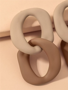 Macro shot of matte acrylic chain link earrings in beige and dark brown tones