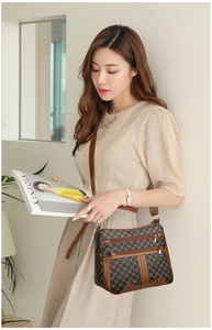Close-up of brown vintage crossbody bag with geometric pattern and multiple zipper pockets