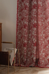 Detailed close-up of Christmas red jacquard curtain with white pompoms and linen texture