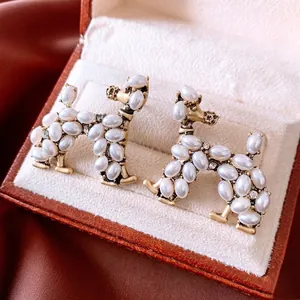 Vintage gold poodle earrings with pearl inlay and crystals in a luxury velvet jewelry box