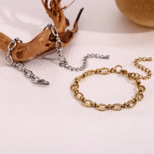 Detail of 14K gold and silver chunky link bracelets with textured oval clasps