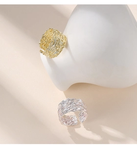 Detail of adjustable silver and gold rings with unique nest-like wire texture