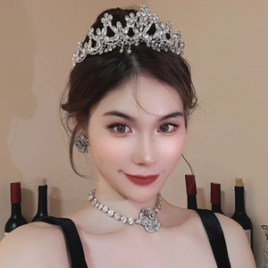 Detailed view of elegant silver crown and jewelry set worn by a model for parties