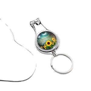 Metal nail clipper keychain featuring sunflower and starry sky art in a circular design
