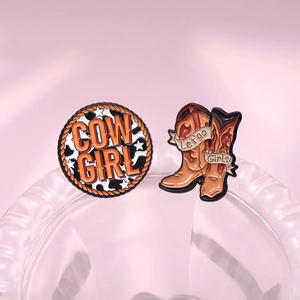 Western cowboy style enamel pins set with Cow Girl badge and boots on a pink background