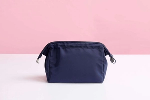 Close-up of durable navy blue waterproof makeup bag with smooth top zipper closure