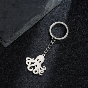 Polished stainless steel octopus pendant keychain on black stone background