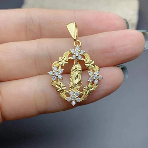 Macro detail of a gold Virgin Mary Guadalupe pendant with zircon clover frame
