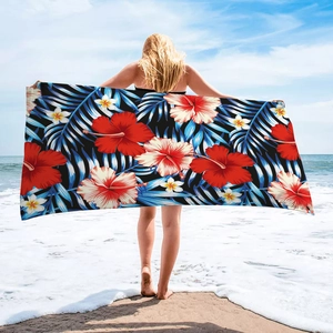 Detailed view of microfiber beach towel with red hibiscus and blue palm leaf prints