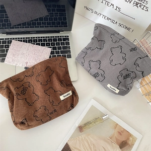 Close-up of soft corduroy cosmetic bags with cute bear prints in brown and gray tones