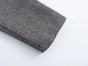 Close-up of elegant herringbone wool fabric texture and stitching on suit jacket sleeve