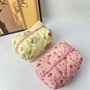 Close-up of quilted floral makeup bags featuring soft cotton texture and pink zipper detail