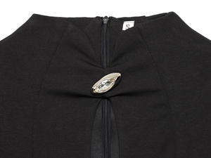 Detail eines schwarzen Maxikleids mit Strass-Schnalle und hochwertigem Reißverschluss