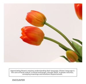 Close-up of artificial tulips with realistic orange-yellow gradient petals on white background